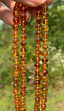 Charger l'image dans la galerie, Perles en ambre, couleur orange avec inclusions, 6mm