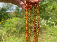 Charger l'image dans la galerie, Perles en ambre, couleur orange avec inclusions, 6mm